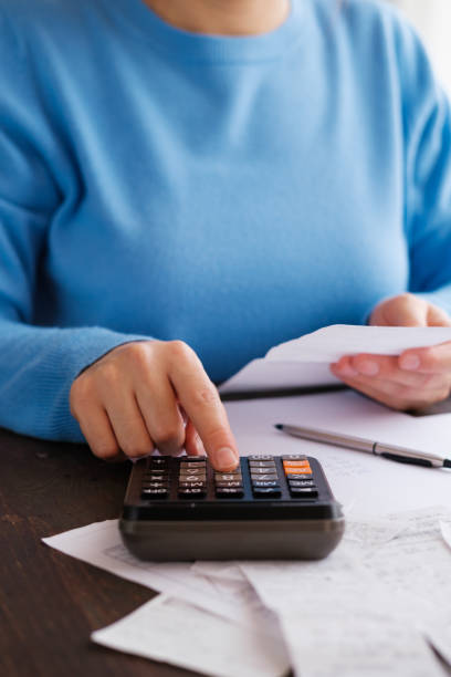 Woman calculating personal expenses at home stock photo