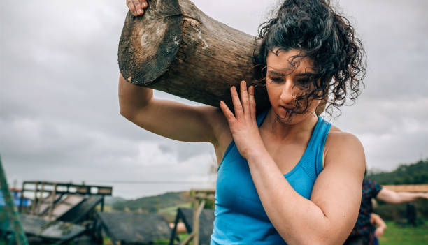 vrouw die een boomstam draagt - bootcamp stockfoto's en -beelden