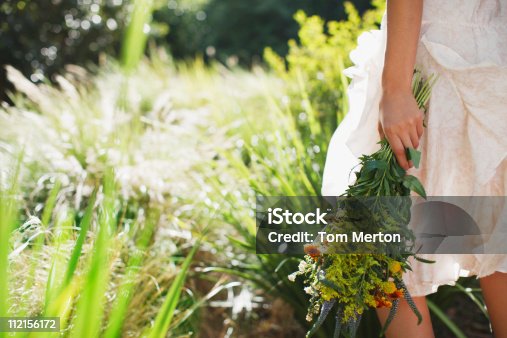 istock Woman carrying flowers in garden 112156172