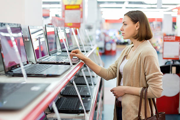 woman chooses the laptop stock photo