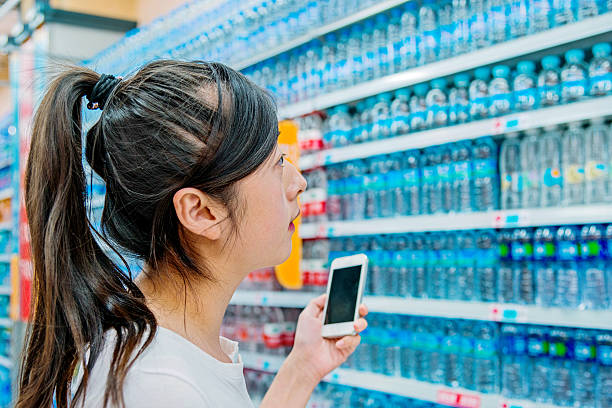 woman choosing bottled water - soda supermarket stockfoto's en -beelden