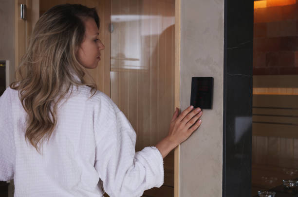Woman choosing infrared sauna temperature. Home Spa concept Woman choosing infrared sauna temperature. Home Spa concept infrared stock pictures, royalty-free photos & images