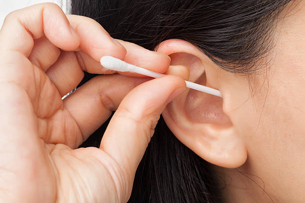 Woman cleaning ear Woman cleaning ear using cotton stick cotton swab stock pictures, royalty-free photos & images