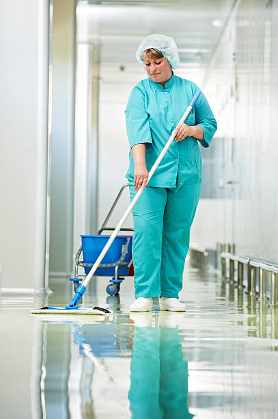 Woman cleaning hospital hall stock photo