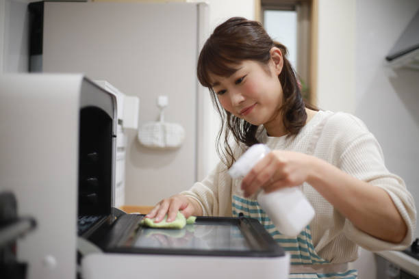 Woman cleaning the microwave stock photo