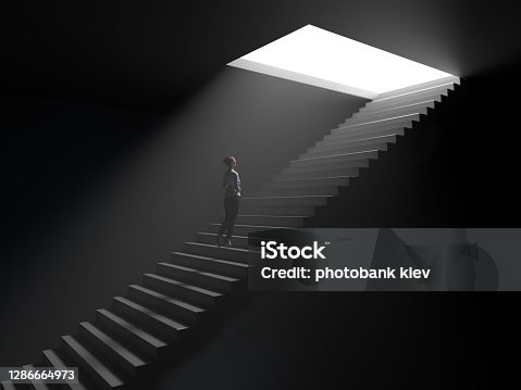 istock woman climbs the stairs from darkness to light 1286664973