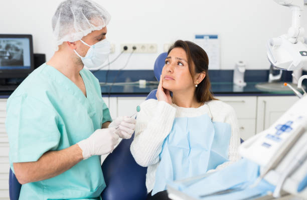 Woman complains of toothache to dentist stock photo