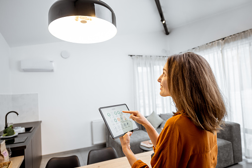 woman controlling light with a digital tablet at home picture id1193467341?b=1&k=20&m=1193467341&s=170667a&w=0&h=MRe97hM 3