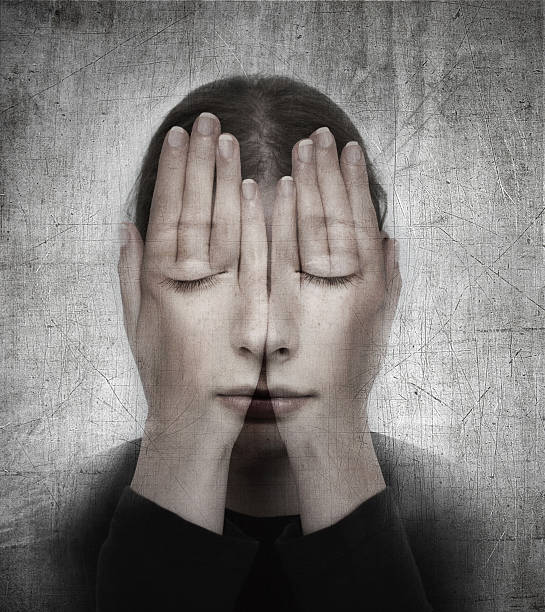 Woman covers her face with hands on the grunge backround. stock photo