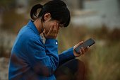 スマートフォンを手に泣いている女性