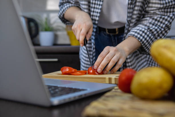 woman cutting tomatoes on the board home kitchen stock photo