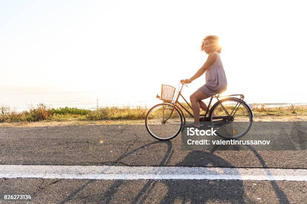 Woman cycling on sunny road