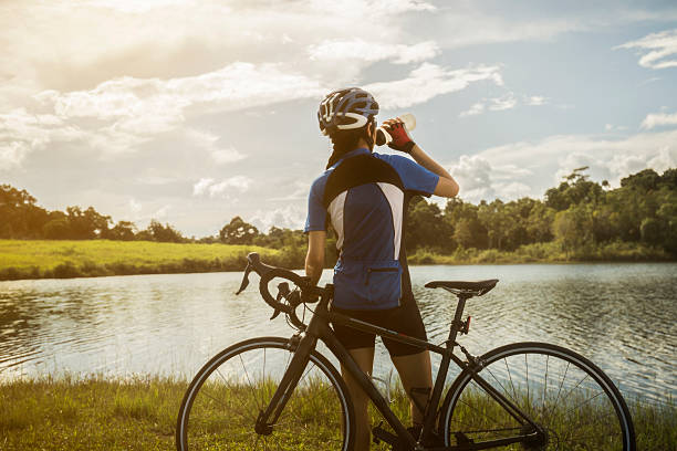 Woman cyclist relaxing drink water from the exercise stock photo