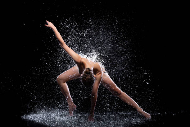 Woman dancer is doing modern art dance in water stock photo