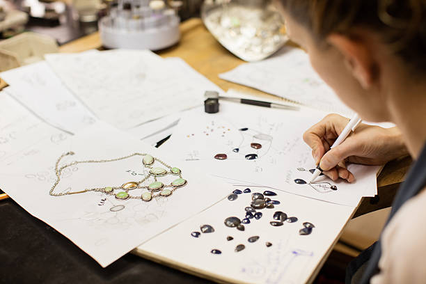 woman designer makes and design jewelry in workshop - sieraden stockfoto's en -beelden