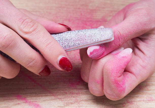 Woman does manicure at home and using a nail file removes old gel polish from her nails. Woman does manicure at home and using a nail file removes old gel polish from her nails. gel nail polish stock pictures, royalty-free photos & images