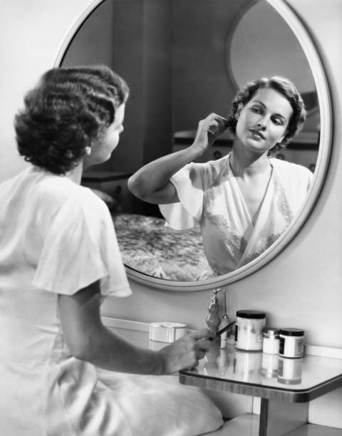 Woman doing hair in front of mirror, (B&W)  dresser photos stock pictures, royalty-free photos & images