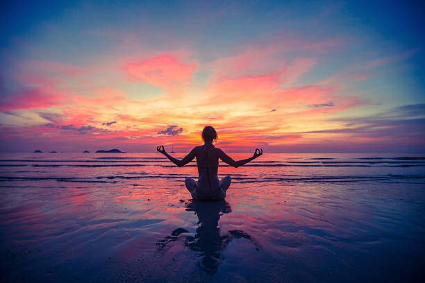 Woman doing meditation near the ocean beach. stock photo