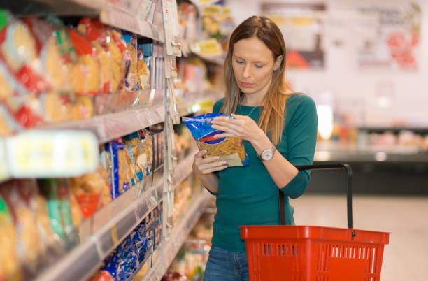 Woman doing shopping of pasta in the mega market Young woman doing shopping of merchandise in the store aisle photos stock pictures, royalty-free photos & images