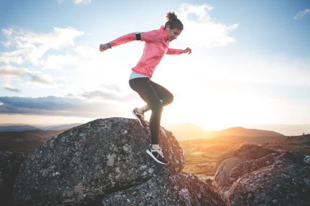 Woman doing workout in the mountains at sunset stock photo