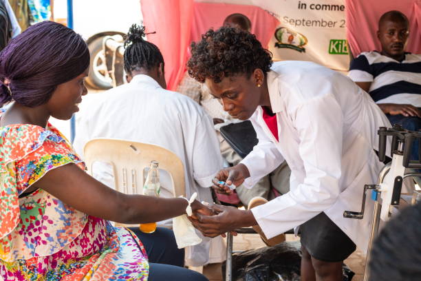Woman donates her blood in a street point in Kampala, Uganda. Kampala, Uganda - January 15th, 2020: Unidentified woman donates her blood in makeshift blood donation street point in Kampala, Uganda. Lack of donated blood is common in Kampala hospitals. africa stock pictures, royalty-free photos & images