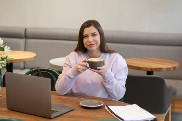 femme buvant du café ou dégustant un cappuccino aromatique le matin dans une maquette d’ordinateur portable de café - ouvrier coeur photos et images de collection