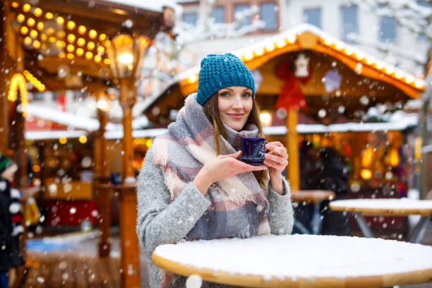 vrouw drinken warme punch op duitse kerstmarkt. - berlin snow stockfoto's en -beelden