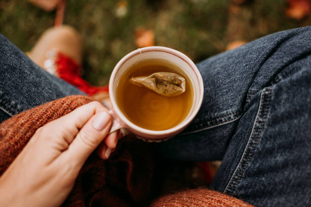 Woman drinking tea outdoors in autumn casual clothing close up of ceramic tea cup Woman drinking tea outdoors in autumn casual clothing close up of ceramic tea cup 
Photo taken outdoors in nature in sunlight tea bag stock pictures, royalty-free photos & images