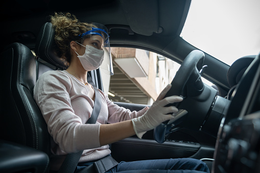Woman Driving A Car Wearing A Facemask And A Face Shield During The Pandemic Stock Photo - Download Image Now - iStock