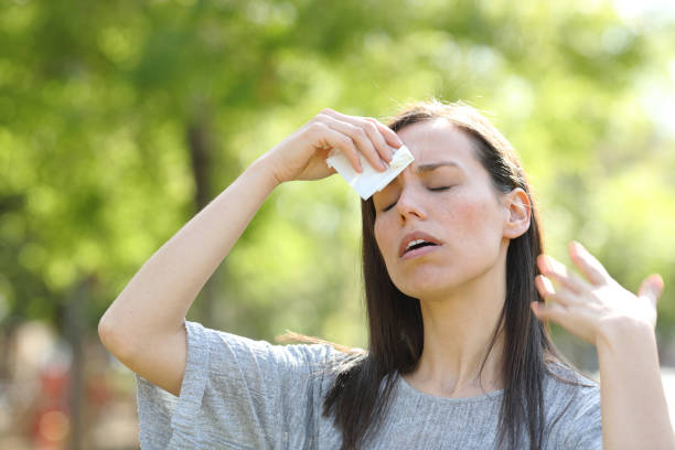 mujer secando el sudor usando una toallita en un caluroso día de verano - sweat fotografías e imágenes de stock