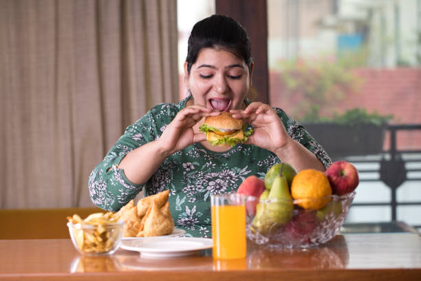 woman eating a fast food burger woman eating a fast food burger cold drink photos stock pictures, royalty-free photos & images