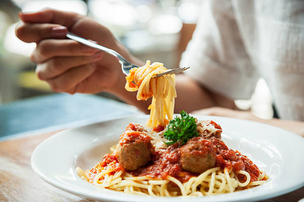 woman eating spaghetti stock photo