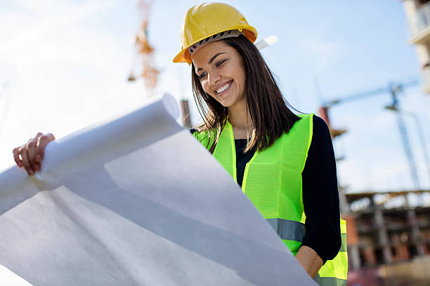 Woman engineer looking at blueprints stock photo