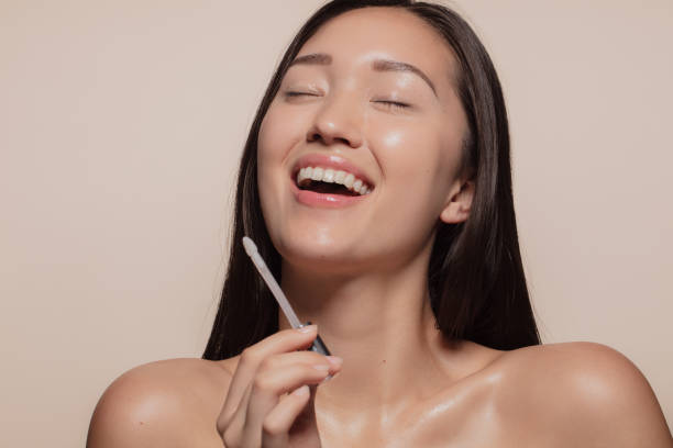 Woman enjoying doing make up Young woman smiling with her eyes closed while doing makeup. Korean female model enjoying doing make up. beautiful polish girls stock pictures, royalty-free photos & images