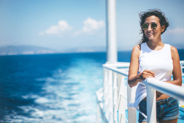 Woman enjoying the sea from cruise ship Young woman on windy cruise ship cruise vacation stock pictures, royalty-free photos & images