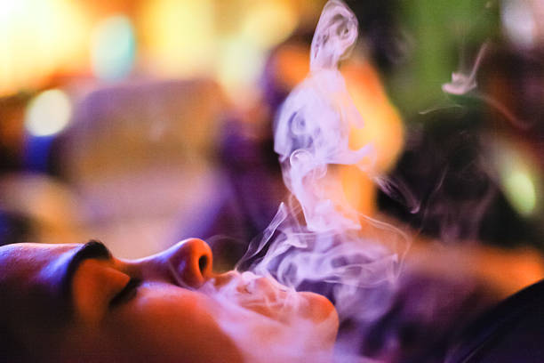 Woman Exhaling Smoke From an E-Cigarette stock photo