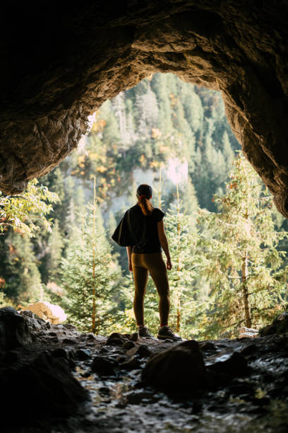 Woman exploring mountain cave stock photo