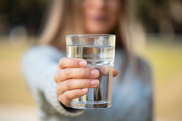 woman extending a glass of water for healthy life stock photo