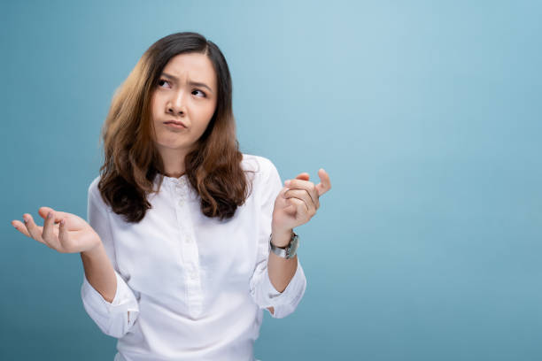 Woman feel confused isolated over blue background stock photo