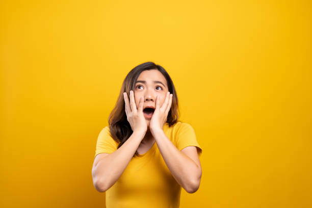 Woman feel scared standing isolated over yellow background stock photo