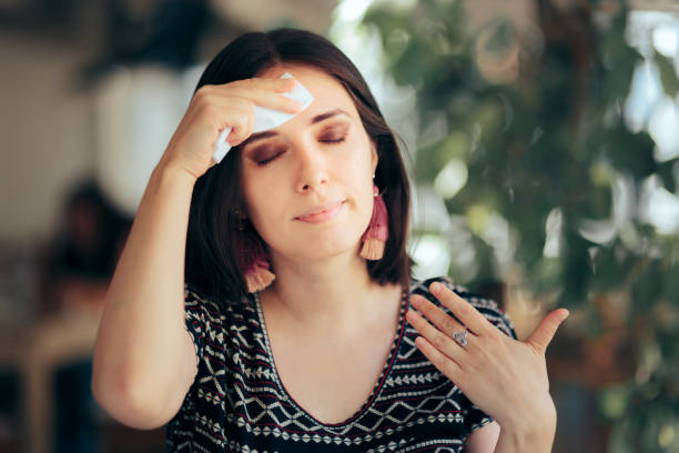Woman Feeling Hot During Summer Wiping Her Forehead stock photo
