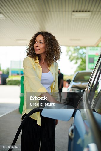 istock woman filling up at the petrol pump 1331083361