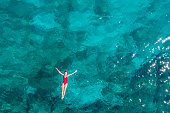 istock Woman floating turquoise sea 1352715203