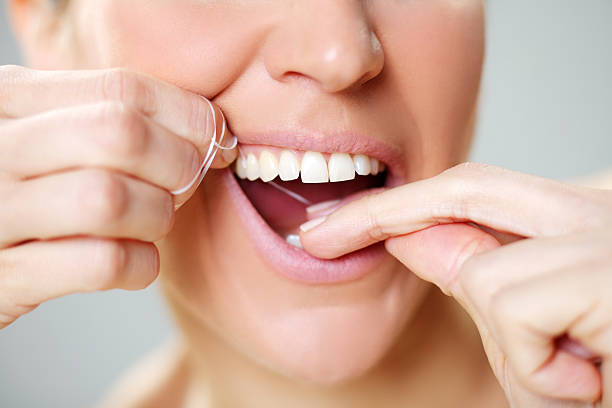 woman flossing teeth stock photo