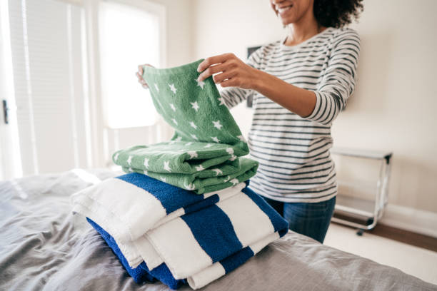 woman folding towels - misturar imagens e fotografias de stock