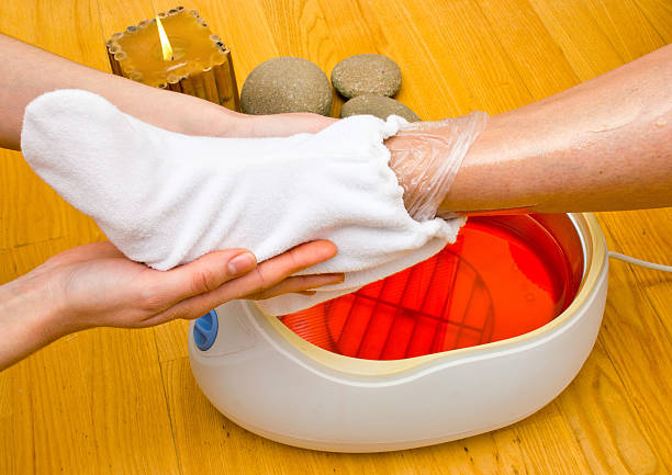 woman foot in paraffin bath at the spa stock photo