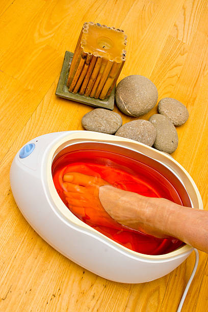 woman foot in paraffin bath at the spa stock photo