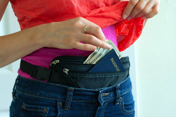 Woman getting cash and passport from hidden travel money belt stock photo