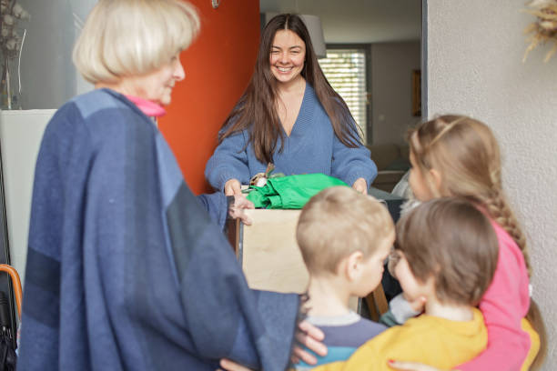 Woman gives refugee clothes and toys to support them stock photo