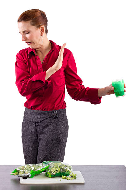 Woman grossed out by green vegetable juice woman grossed out by green vegetable juice ugly skinny women stock pictures, royalty-free photos & images